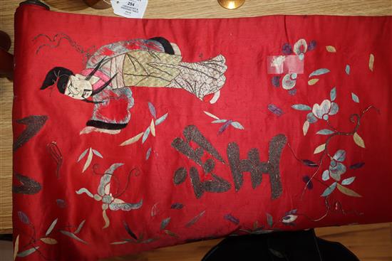 A Chinese red silk banner embroidered with figures, flowers, insects and calligraphy,